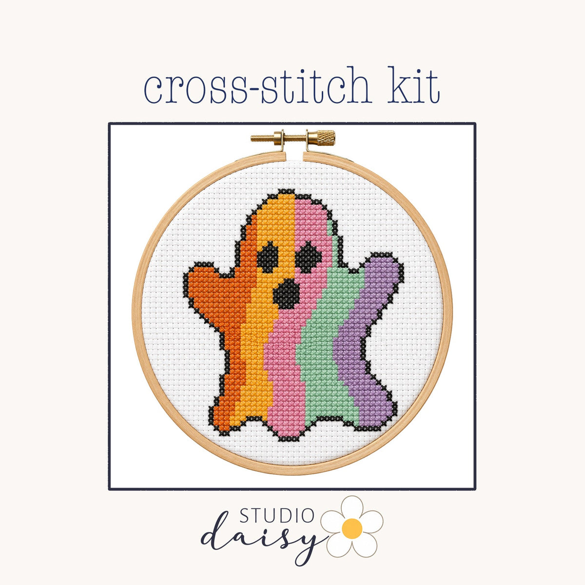 A cross-stitch kit preview showing a wooden hoop with a colorful stitched ghost design on white fabric, centered on a light beige background with the text 'cross-stitch kit' above and 'STUDIO daisy' below.